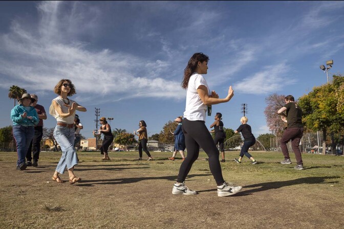 Rehearsals of “ALL AGAIN” by a community chorus show people executing moves in a circle.