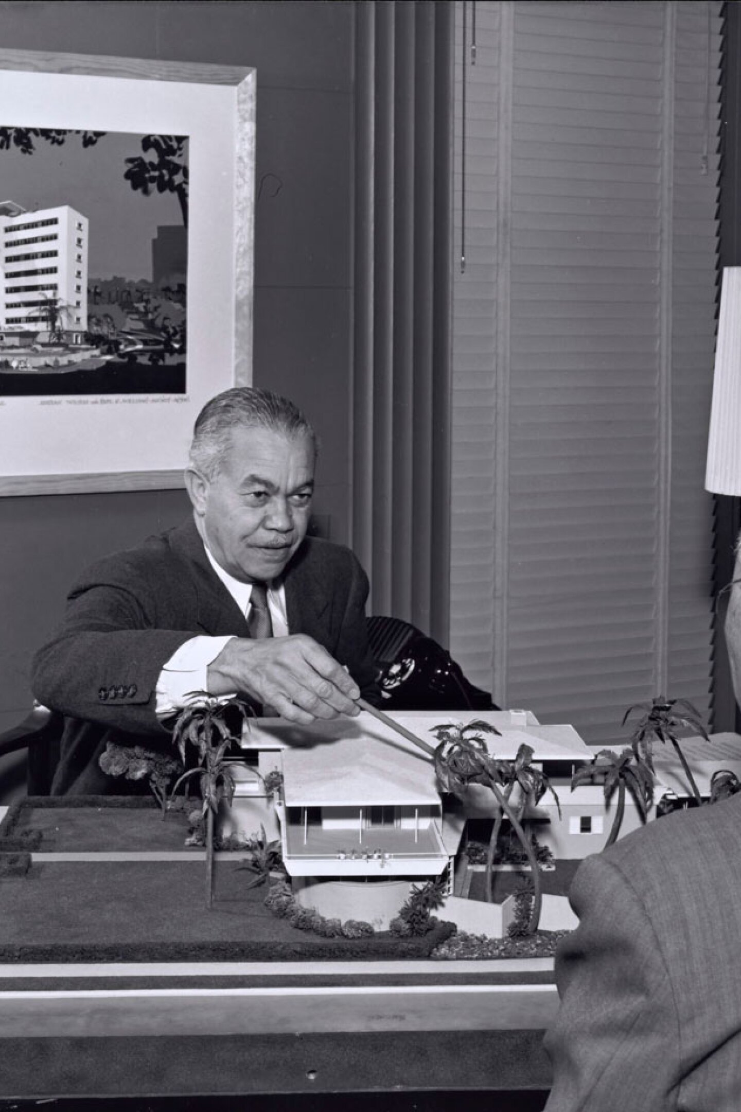 Paul R. Williams on the other side of the desk showing plans | J. Paul Getty Trust. Getty Research Institute, Los Angeles