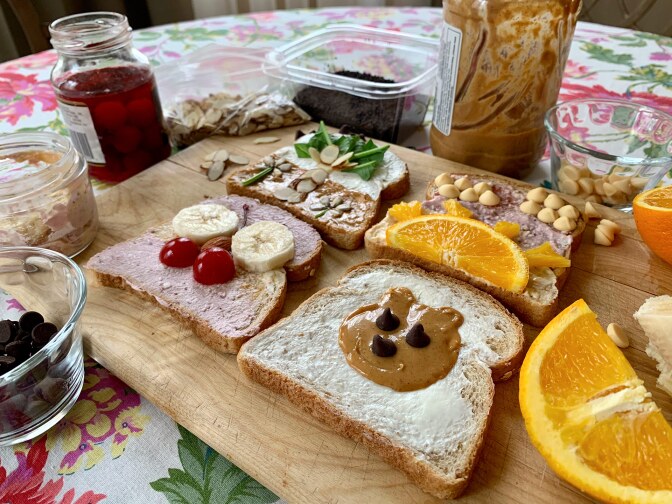 Four pieces of decorated toast featuring a palm tree, sunset, butterfly and teddy bear.