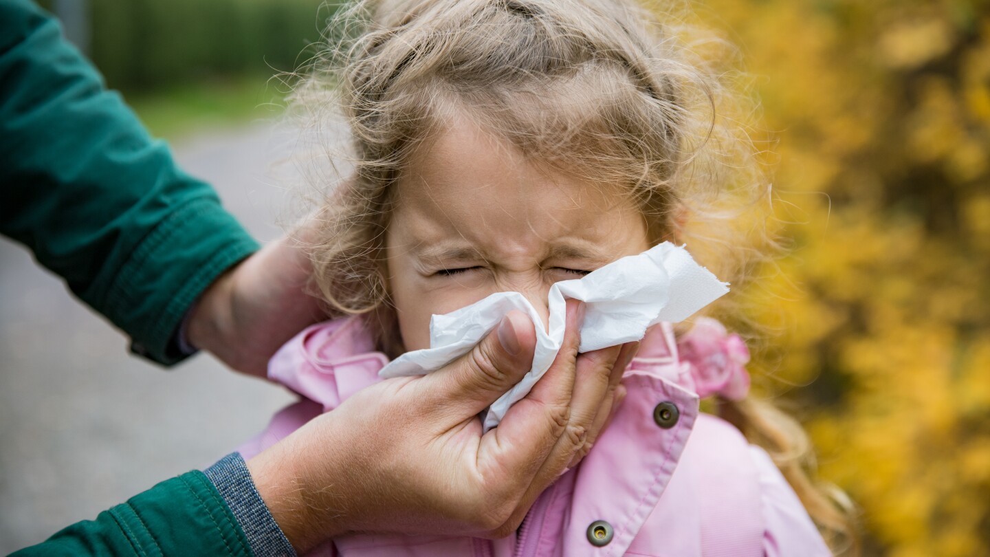 Father wiping daughter's nose with handkerchief