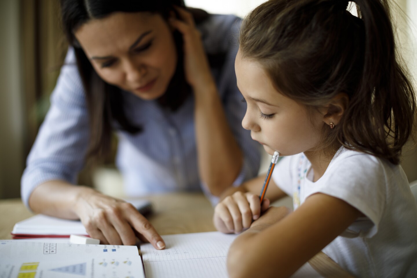 Young student being tutored by an adult. | iStock