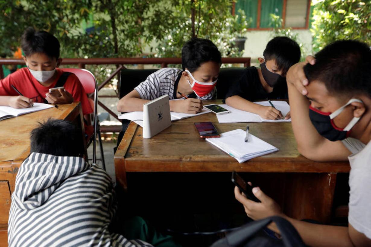 Dimas Anwar Saputra, wearing a red mask, studies with other students using free internet Wi-F access that they got by exchanging plastic waste, amid the coronavirus disease (COVID-19) outbreak, in Jakarta, Indonesia, September 9, 2020. REUTERS/Willy Kurn
