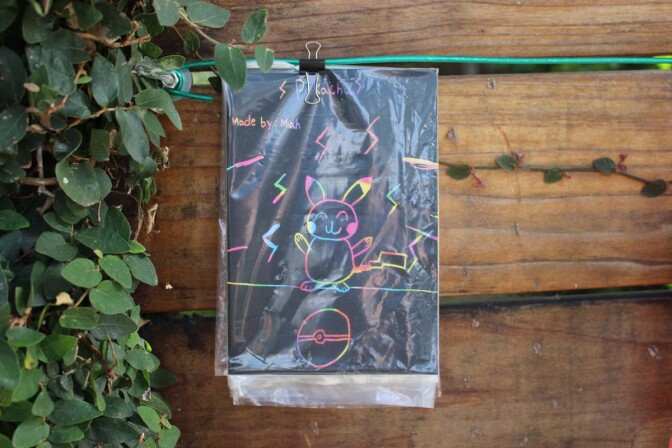 A Pokémon drawing made by a child artist, Miah, hangs on Dan Fields’ Los Feliz fence gallery