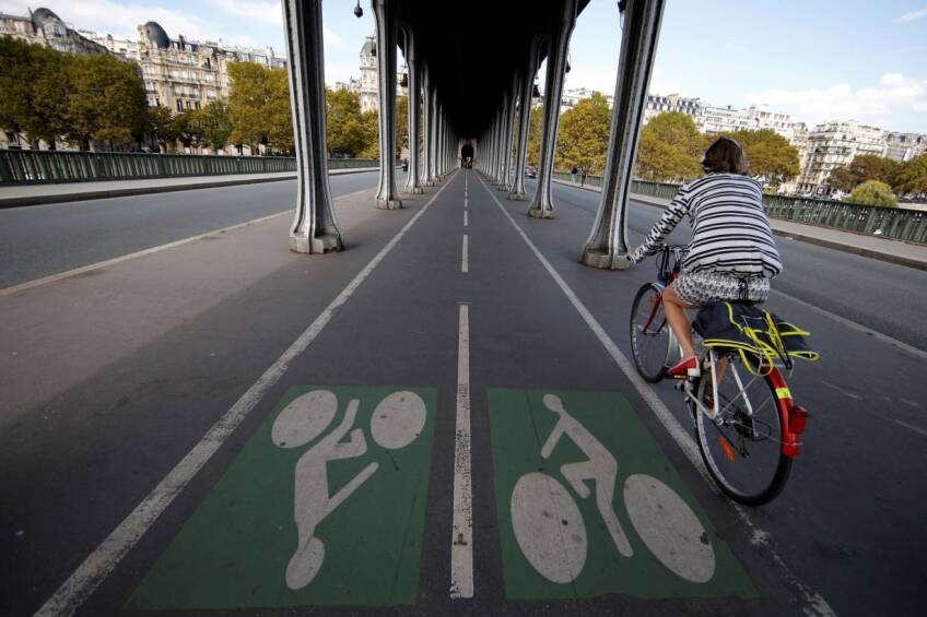 ARCHIVE PHOTO: A woman rides a bicycle along a bike path on the Pont de Bir-Hakeim bridge in Paris, France, September 14, 2018. | REUTERS/Gonzalo Fuentes