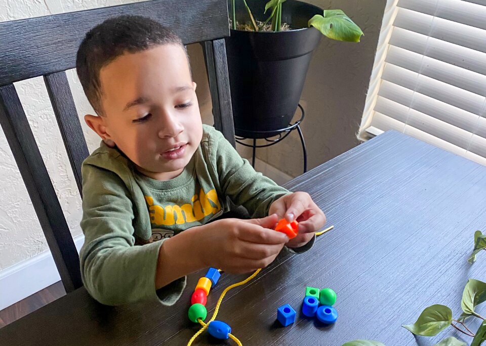 A child makes a bead bracelet