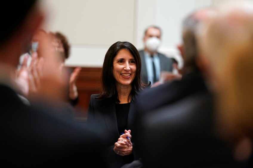 Justice Patricia Guerrero stands with her hands clasped in a crowd of applauding people