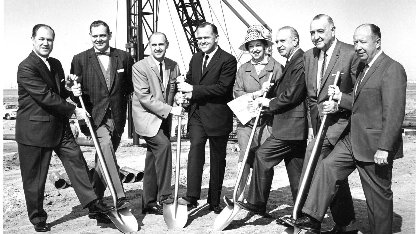 A group of people pose with shovels at a groundbreaking ceremony.