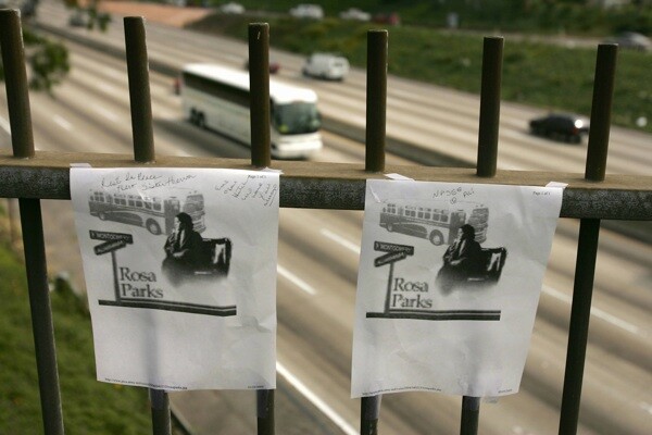 Photos of Rosa Parks hang at a highway overpass in Los Angeles named for the American civil rights icon after a tribute by black community leaders on October 25, 2005. | Photo: ROBYN BECK/AFP/Getty Images