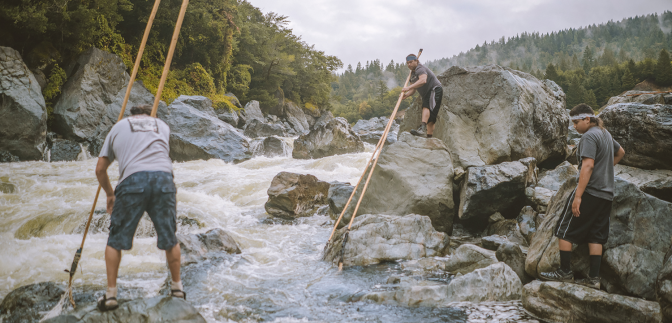 3 people fish in a river