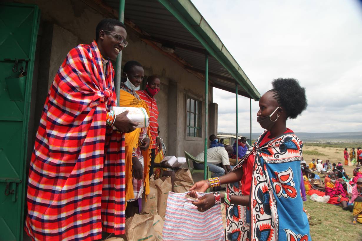 Nelson Ole Reiyia, founder of the Nashulai Maasai Conservancy, distributes food rations to community members at the conservancy located near the Maasai Mara National Reserve in Narok county, Kenya on July 14, 2020. |THOMSON REUTERS FOUNDATION/Nita Bhalla
