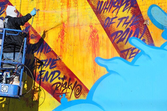 Final touches on RISK's mural on the border of the Arts District and Skid Row | Photo: MOCA.