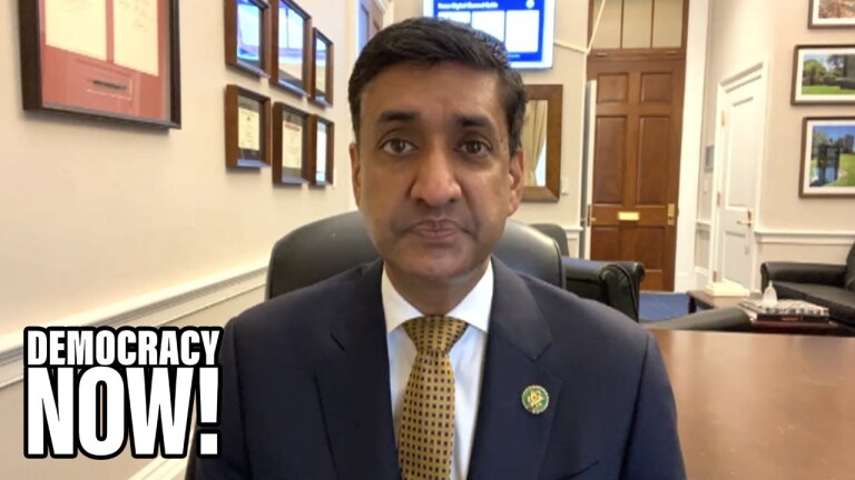 A person wearing a suit sitting in an office is on video call.