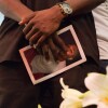 A friend of Josiah Lawson at his memorial, holding a photo of David Josiah Lawson in his hands. | Still from "Who Killed Josiah?" | Courtesy Mark McKenna
