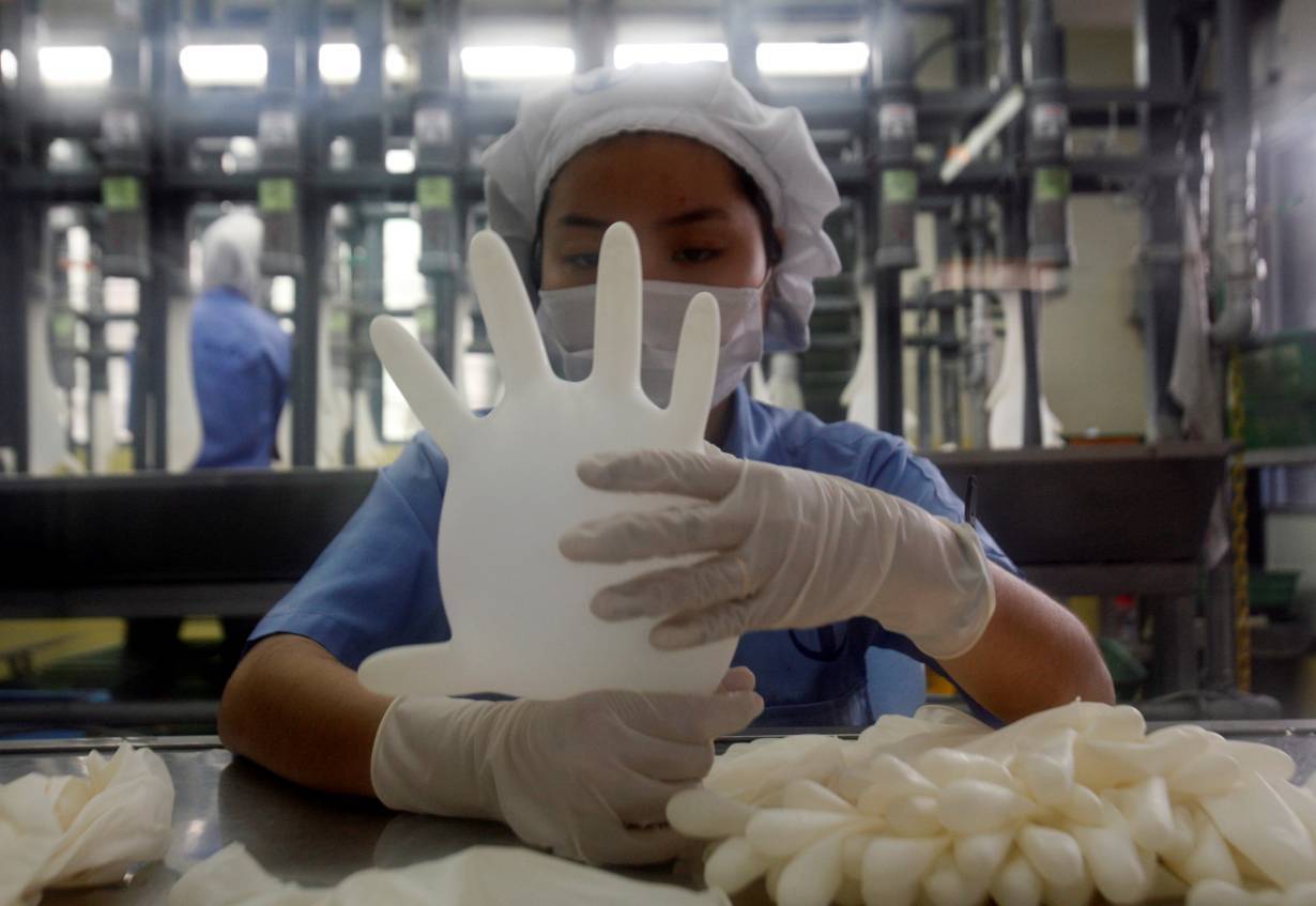 49-xxtxt left"> <p>FILE PHOTO: A worker carries out a test on a glove at a Top Glove factory outside Kuala Lumpur June 25, 2009. | REUTERS/Bazuki Muhammad
