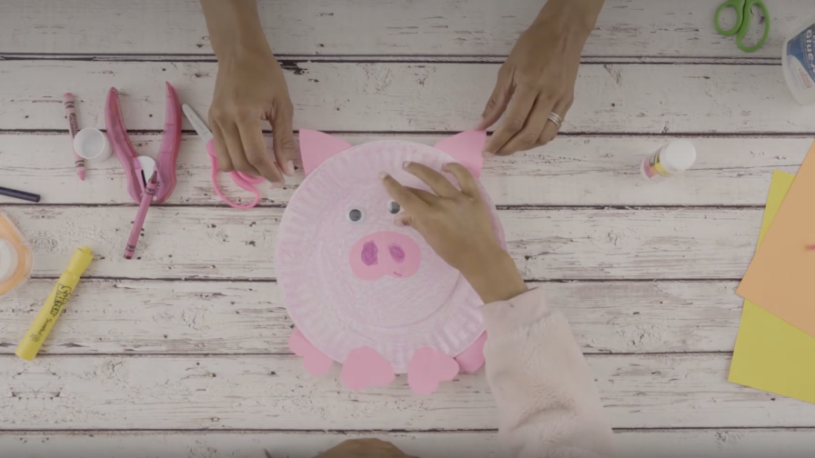 A pink piggy, a yellow chicklet and a purple spider made out of paper plates against a white background.