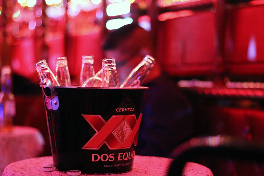 A Dos Equis bucket and empty bottles of beer.