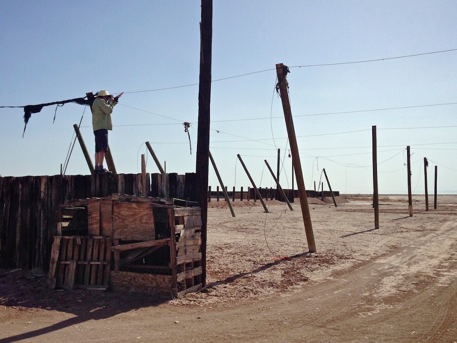 Photographer on desert ruin capturing first image in article. Salton Sea, CA. 2014. | Photo: Christopher Langley.