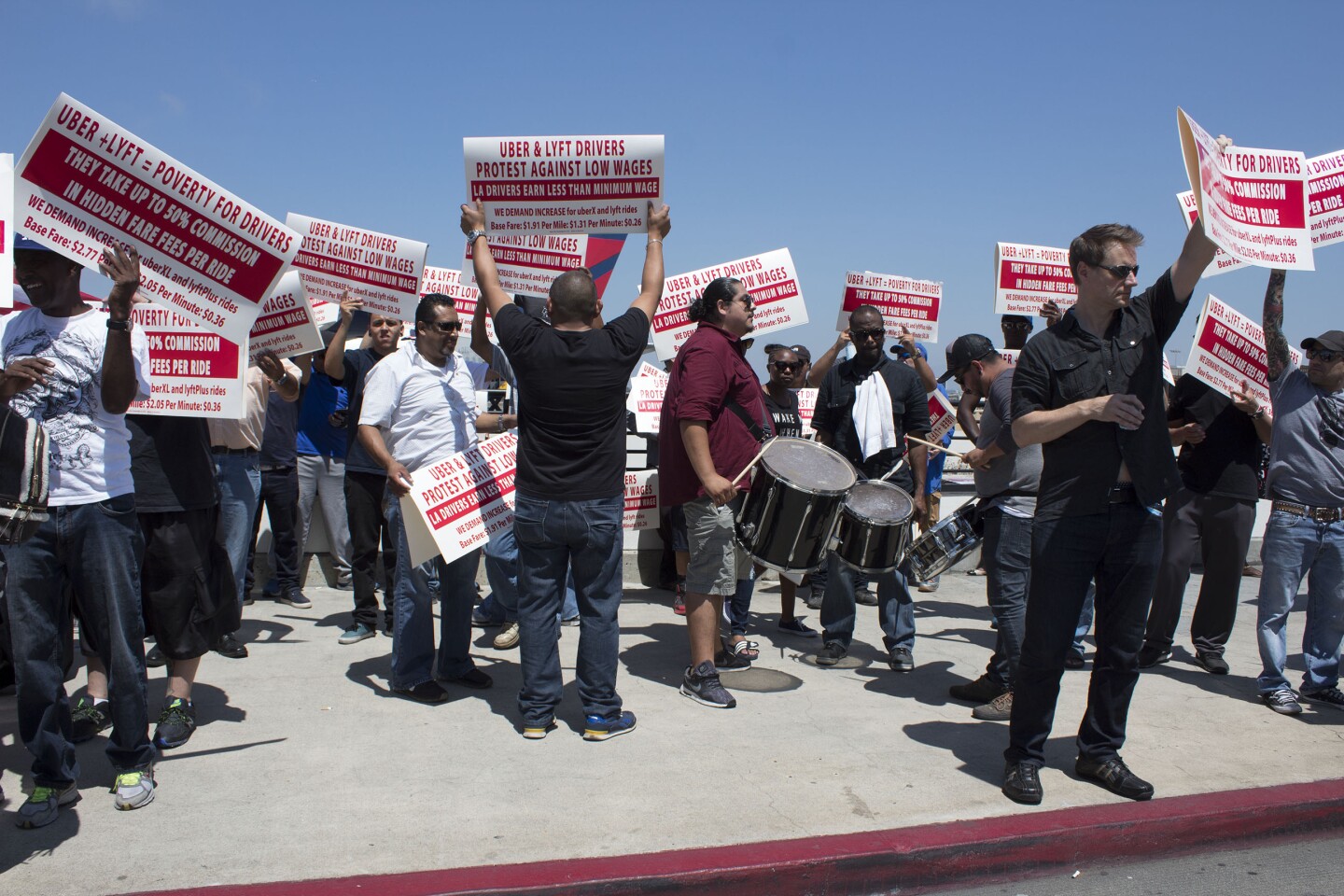 LAX Rideshare Protesters hold signs curbside