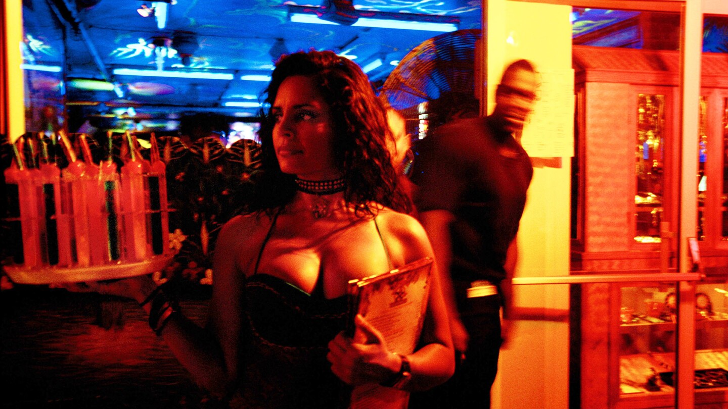 A waitress holds alcoholic drinks in the entrance to a restaurant in Miami Beach, Florida. | Yoray Liberman/Getty Images