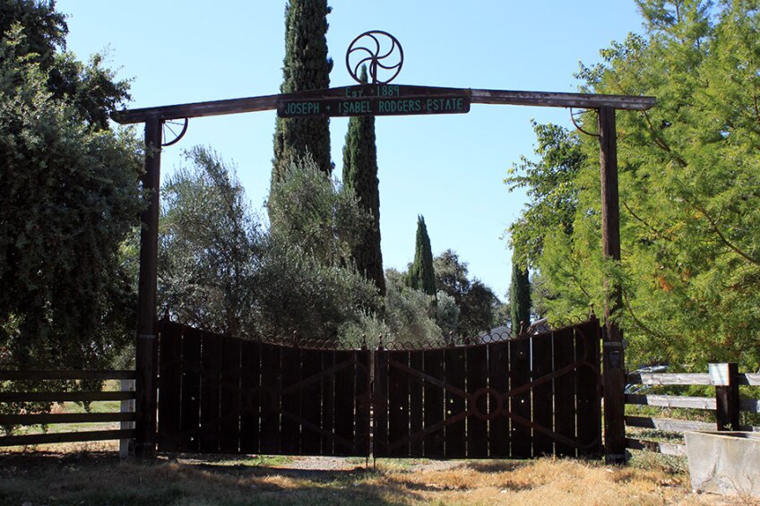 Outdoor Wooden Gate Reading "Est. 1889 - Joseph + Isabel Rodgers Estate"