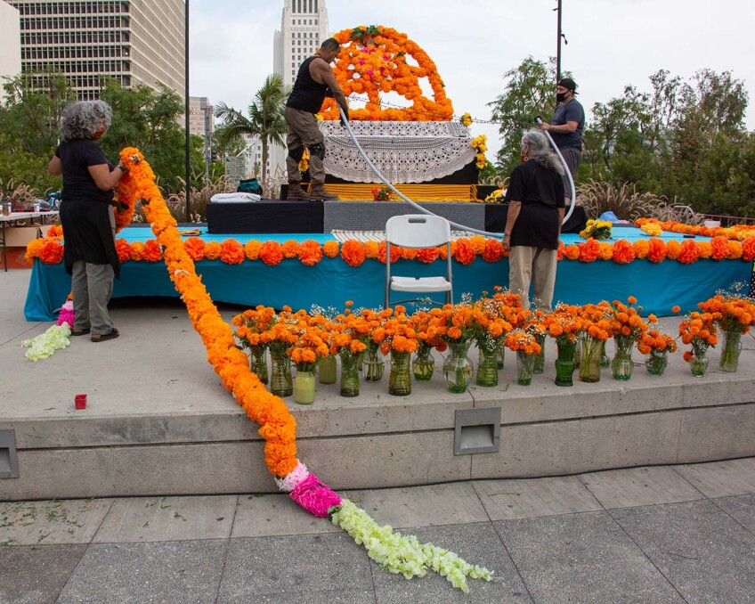 People working on putting up decorations on an ofrenda for Día de los Muertos 2020 | Rafael Cardenas at Grand Park