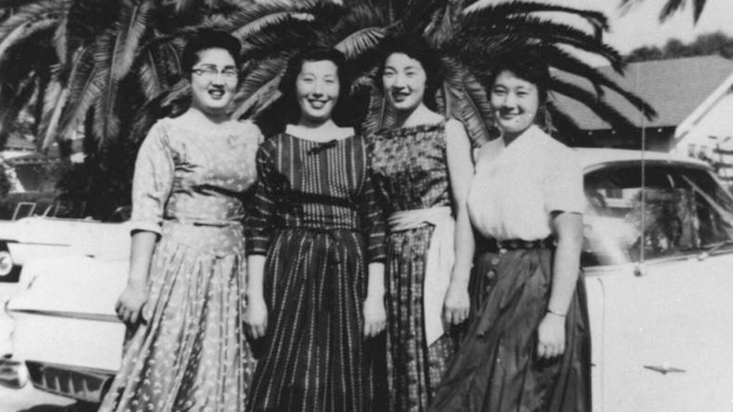 Black and white photo of Setsuko, Taeko, Kou and Keiko Hasegawa posing together under palm trees, 1954
