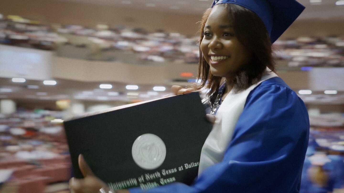 Woman receiving a diploma at graduation ceremony. | Featured "Global Mosaic" Image