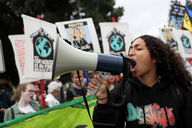A youth climate activist uses a bullhorn as she leads a chant during a Climate Strike youth protest outside of Chevron headquarters on September 27, 2019 in San Ramon, California. | Justin Sullivan/Getty Images
