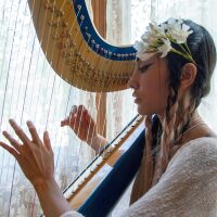 Low Leaf plays her harp inside the Perry House at Heritage Square Museum. | Azul Amaral