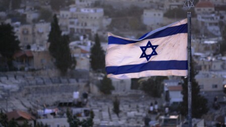 A raised flag of Israel.