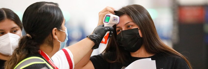 A Passenger Service Representative for Avianca Airlines in the Tom Bradley International Terminal at LAX takes the temperature of Cindy Perla on Nov. 16, 2020 in Los Angeles. | Al Seib / Los Angeles Times