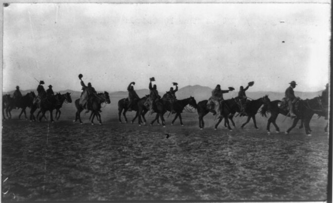 Members of the 10th Cavalry (African American) waving hats as they ride on a U.S. campaign against Pancho Villa at the Mexican border. (1916) | Library of Congress