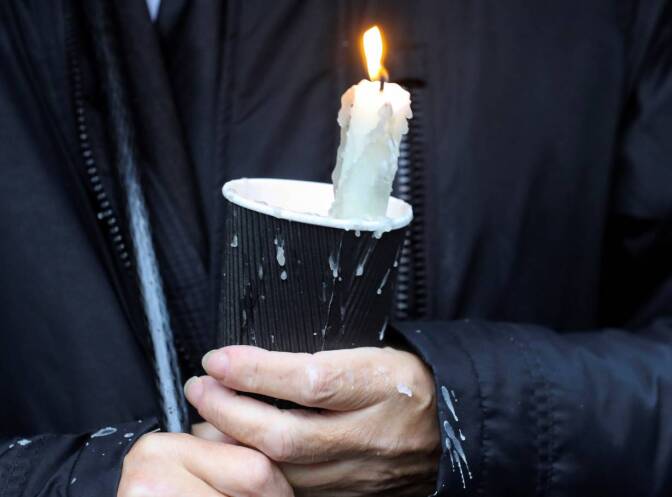A mourner holds a candle outside St Eugene's Cathedral in Londonderry, Northern Ireland August 4, 2020. | REUTERS/Lorraine O'Sullivan
