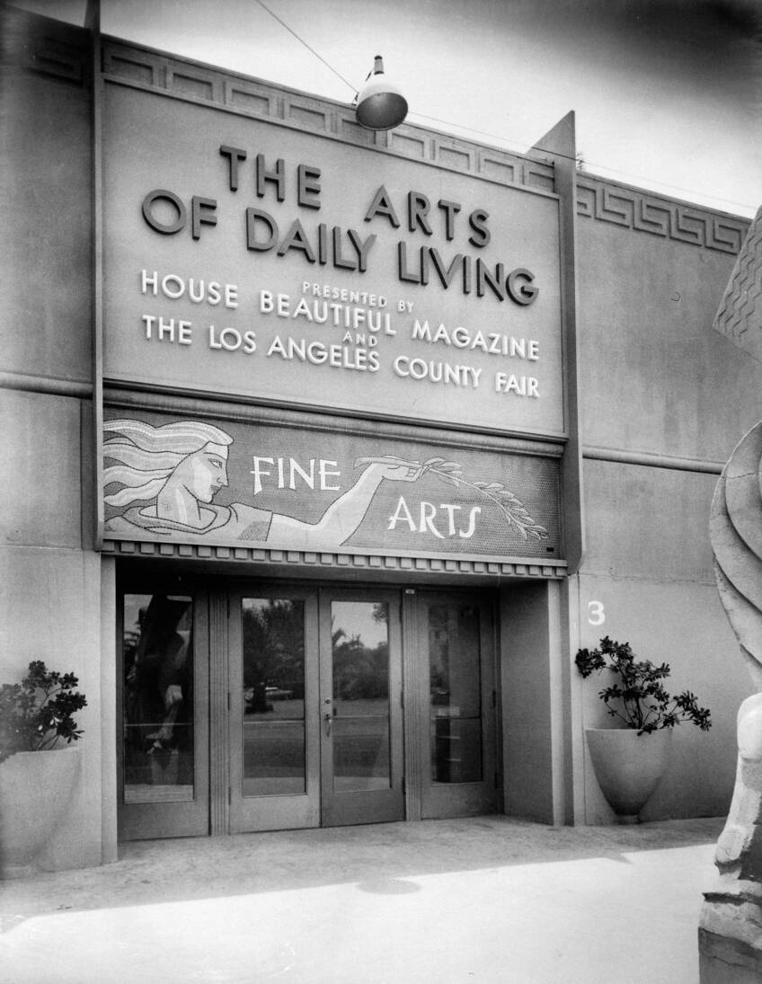 A black and white photo of a building designed with ancient Greek design elements. The sign over the doors read, "The Arts of Daily Living presented by House Beautiful magazine and The Los Angeles County Fair." Below that reads, "Fine Arts."