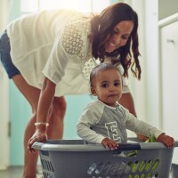Photo of a mother and her adorable baby boy doing laundry at home