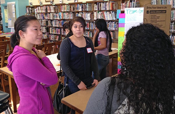 Pamela and Karina from Team Blue and Team Green talk to a community member about their respective projects to revitalize the L.A. River