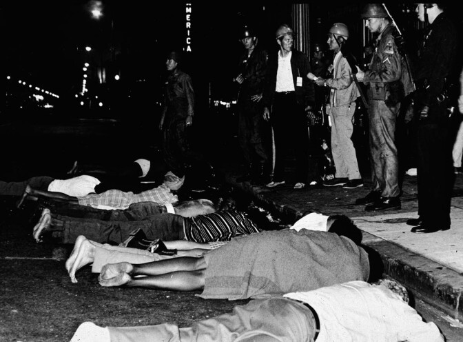 Armed police stand by as rioters lay face down in the street during the Watts race riots, Los Angeles, California, August 1965 | Hulton Archive/Getty Images