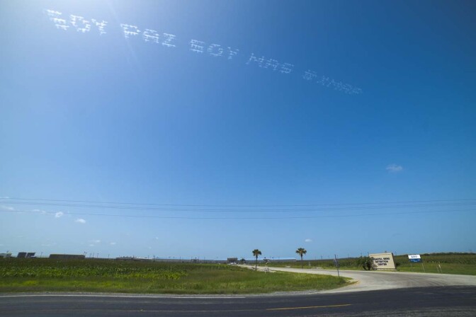 "SOY PAZ SOY MAS #XMAP" written in in the sky, contributed by Maria Gaspar over Coastal Bend Detention Center | Ronald L. Jones, In Plain Sight