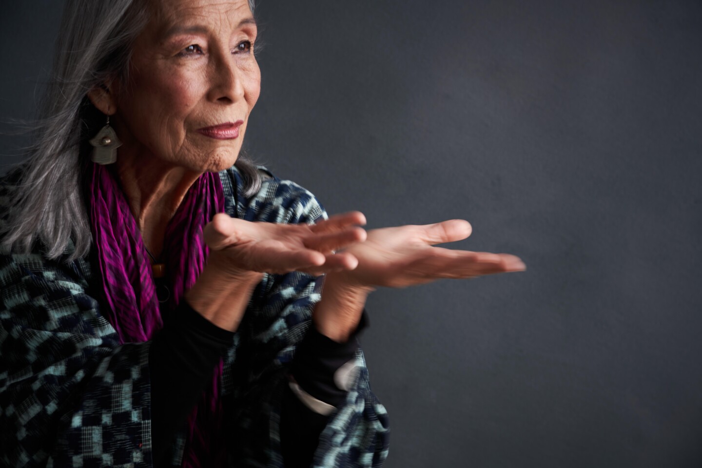 Singer, dancer and activist Nobuko Miyamoto holds her hands out.