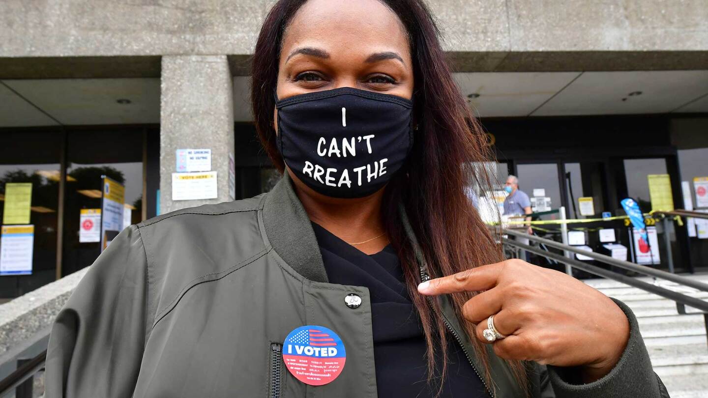 Tonya Swain points to her "I Voted" sticker after casting her vote in the 2020 US elections at the Los Angeles County Registrar in Norwalk, CA.
