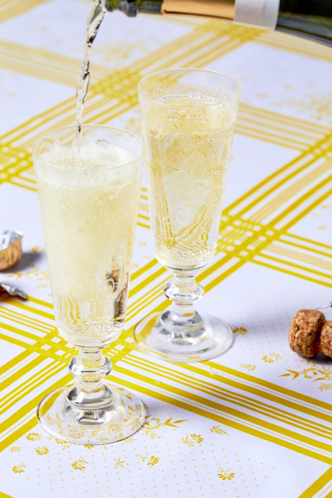 Russian sparkling wine being poured into two glasses from a bottle.