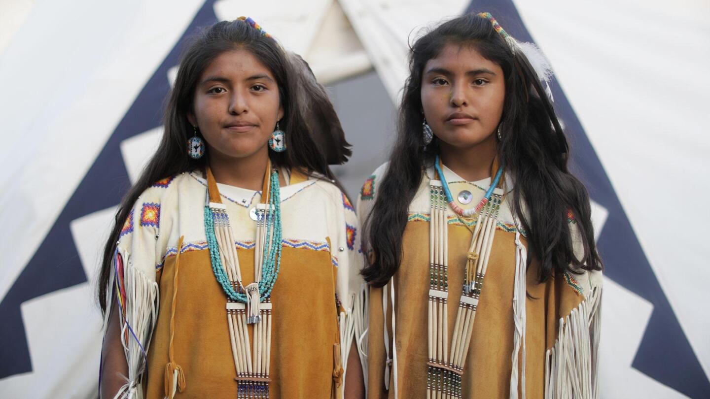 Two young girls wearing traditional clothing stand side by side for a picture. | From "Earth's Sacred Wonders: Visions of the Divine"