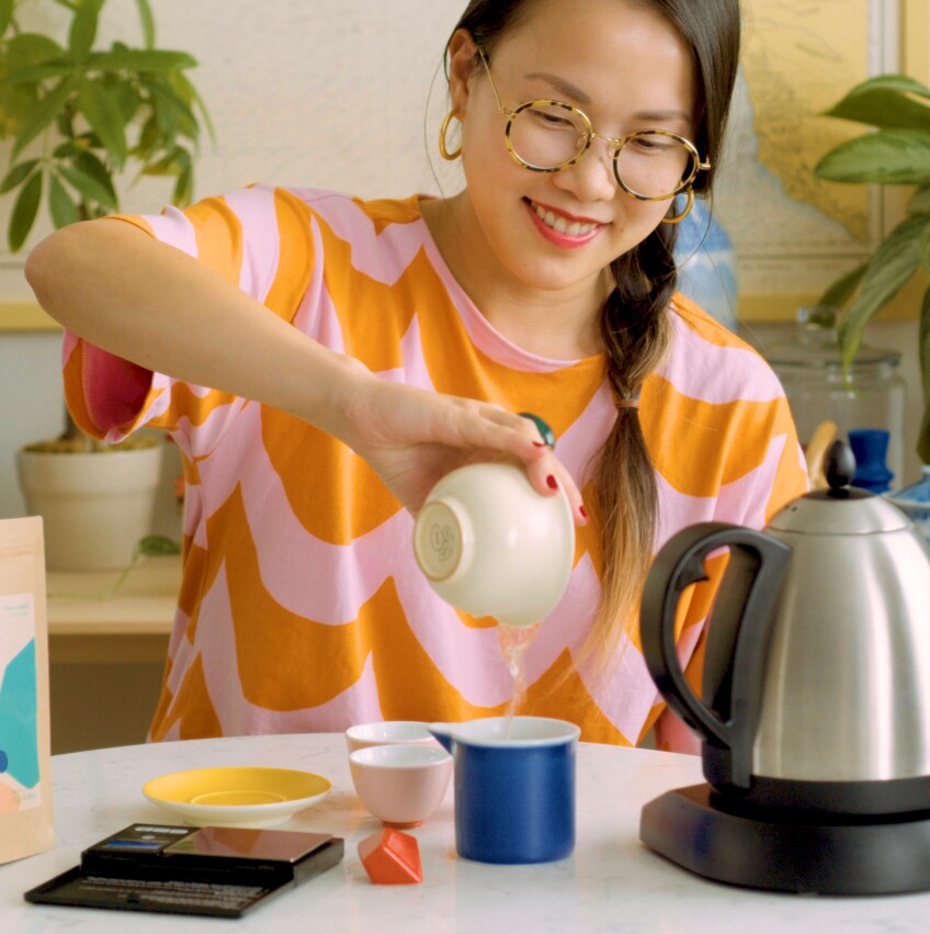 Diana Zheng pours hot water from a bowl into a cup to brew a Teochew dancong tea.