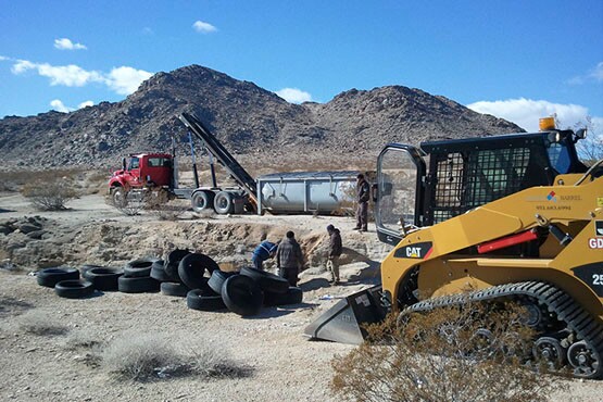 BLM officials cleaning up an illegal tire dump on public lands. | Photo: Courtesy BLM.