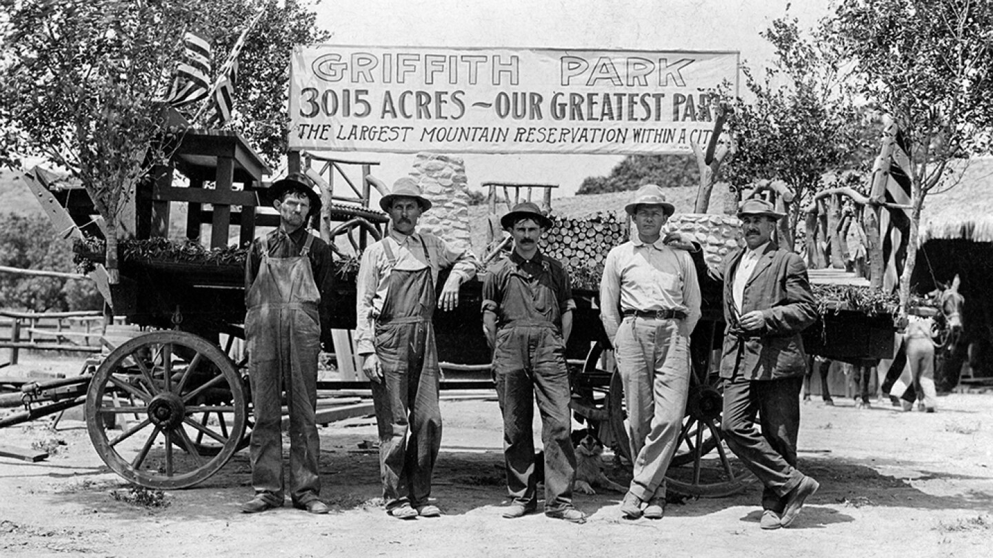A group of men stand before a wagon and a hand-painted banner, "Griffith Park, 3015 acres — Our greatest park. The largest mountain reservation within a city." | UCLA, Library Special Collections, Charles E. Young Research Library