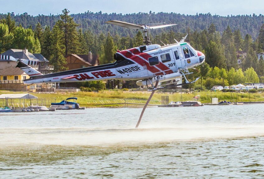 A CAL FIRE helicopter loads water through a snorkel to fill the water tank. | Courtesy of Cliff Walters