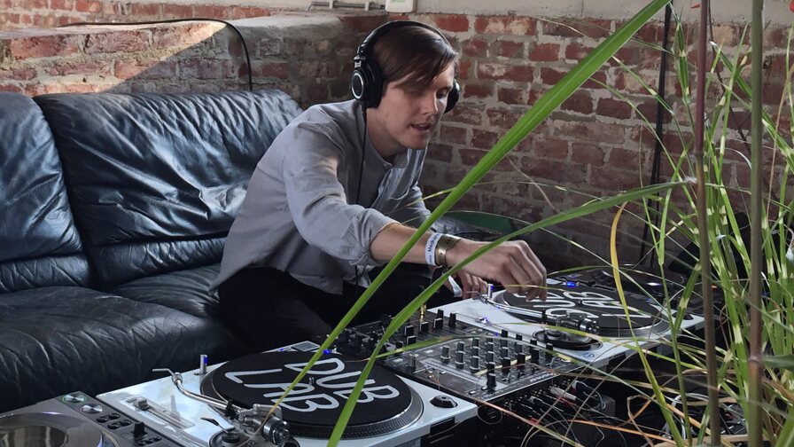 Mark “Frosty” McNeill spins vinyl on a couch. | Courtesy of Mark “Frosty” McNeill