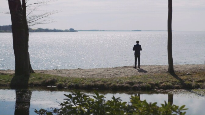A man stands beside a vast lake. | From "Link Voices: Finding Hygge"