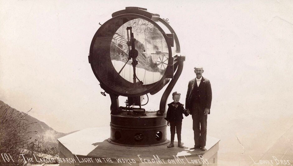 A man and child stand next to the Echo Mountain searchlight
