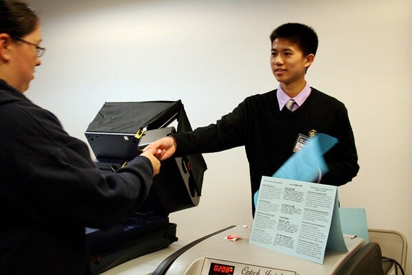 A voter in San Francisco turns in her ballot and receives an 'I voted' sticker.